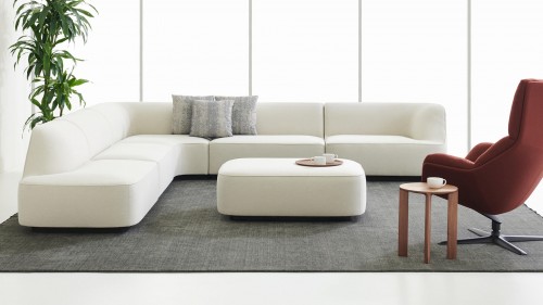 A contemporary lounge setting featuring the SoMod sectional sofa, Cova lounge chair, and Hans table by Davis Furniture